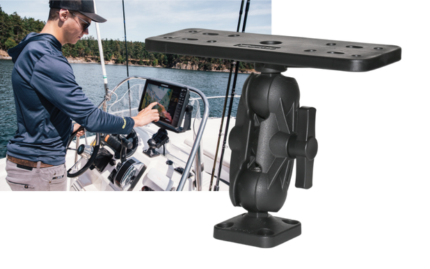 Man standing in boat on water touching depth finder screen
