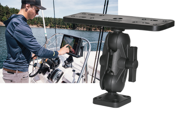 Man standing in boat on water touching depth finder screen